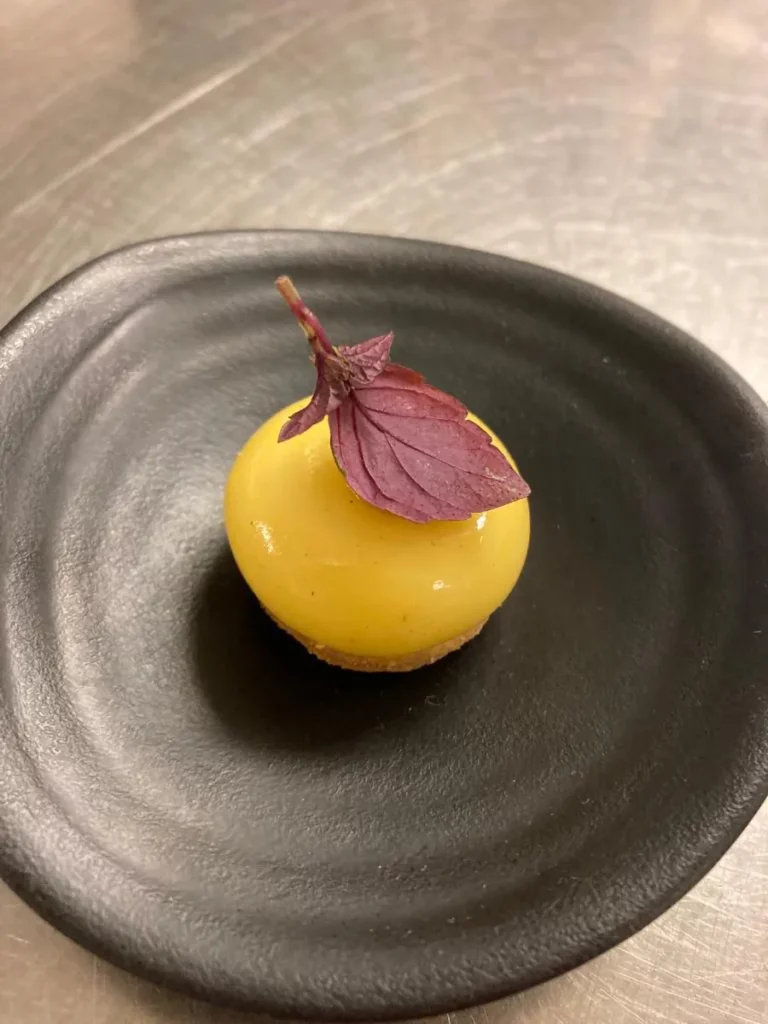 Canape geserveerd met een bonbon van oude kaas met shiso purper